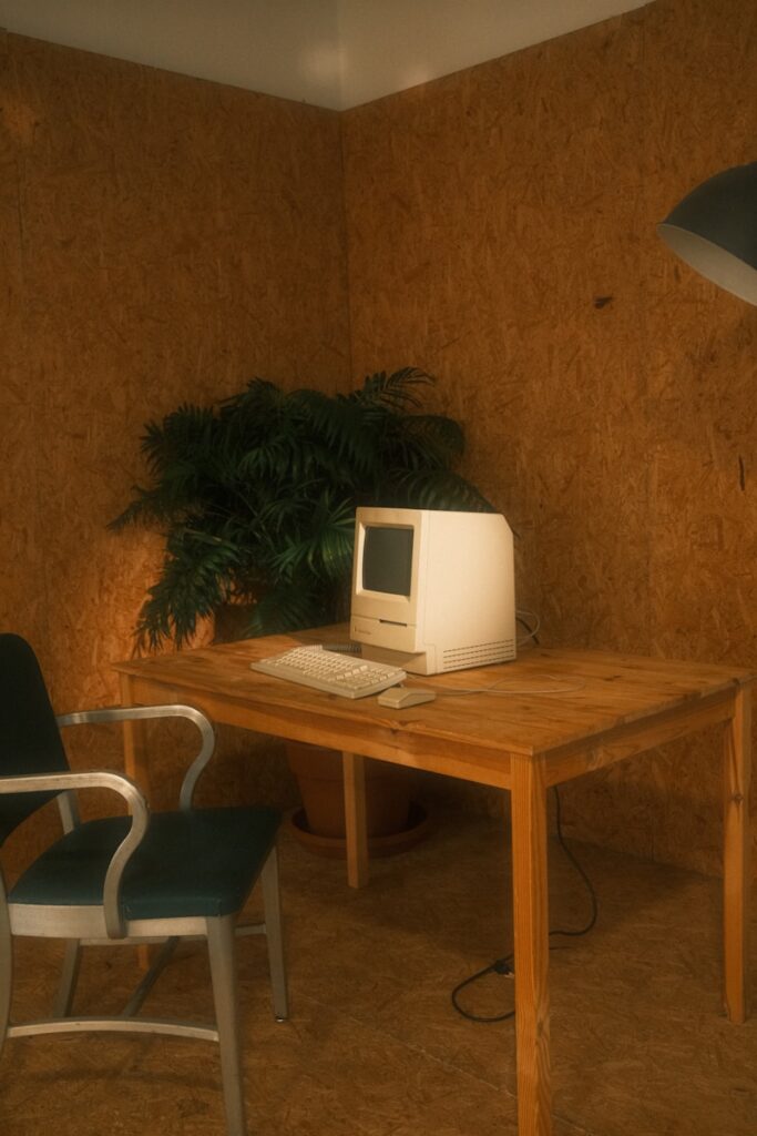 a desk with a old computer and a chair